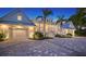 Brightly lit waterfront home with a white exterior, metal roof, and paver driveway at 178 N Washington Dr, Sarasota, FL 34236