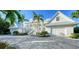 Stunning waterfront home boasts a white exterior, metal roof, and paver driveway at 178 N Washington Dr, Sarasota, FL 34236