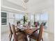 Bright dining room featuring a modern chandelier and balcony access with water views at 258 Golden Gate Pt # 801, Sarasota, FL 34236