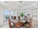 Formal dining room featuring a modern chandelier and balcony access with water views at 258 Golden Gate Pt # 801, Sarasota, FL 34236