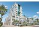 Exterior of the luxury condo building surrounded by palm trees on a sunny day at 258 Golden Gate Pt # 801, Sarasota, FL 34236