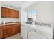 This bright laundry room features wooden cabinets, and modern washer and dryer at 258 Golden Gate Pt # 801, Sarasota, FL 34236