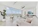 Bright living room features floor-to-ceiling windows with stunning water views and a comfortable white sectional sofa at 258 Golden Gate Pt # 801, Sarasota, FL 34236