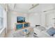 Bright living room featuring a modern television display and large windows for ample natural light at 258 Golden Gate Pt # 801, Sarasota, FL 34236