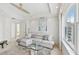 Bright living room with a white leather sectional sofa, plush rug, and modern decor at 258 Golden Gate Pt # 801, Sarasota, FL 34236