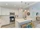 Modern kitchen with white cabinets, stainless steel appliances, and an island with seating at 312 Hardin Ave, Anna Maria, FL 34216