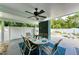 Covered patio with dining table, ceiling fan, and lush landscaping at 312 Hardin Ave, Anna Maria, FL 34216