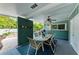 Covered patio with dining table set for six, adjacent to the pool at 312 Hardin Ave, Anna Maria, FL 34216