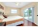 Bedroom with beige bedding, hardwood floors, and sliding glass doors to patio at 3215 Lake View Blvd, Port Charlotte, FL 33948