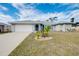 Single-story home with gray siding, white garage door, and landscaped lawn at 3215 Lake View Blvd, Port Charlotte, FL 33948