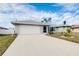 Single-story home with gray siding, white garage door, and landscaped lawn at 3215 Lake View Blvd, Port Charlotte, FL 33948