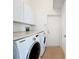 Laundry room with washer, dryer, and storage cabinets at 4867 Sabal Lake Cir, Sarasota, FL 34238