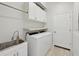 Bright laundry room with washer, dryer, cabinets, and a utility sink at 5060 Lake Overlook Ave, Bradenton, FL 34208