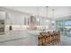 Bright kitchen features white cabinets, marble countertops, and an island with seating at 5252 Willow Lake Ct, Sarasota, FL 34233