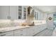 White kitchen with marble countertops, glass-front cabinets, and a gas cooktop at 5252 Willow Lake Ct, Sarasota, FL 34233