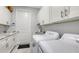 Well-appointed laundry room with white cabinets and a modern washer and dryer at 5252 Willow Lake Ct, Sarasota, FL 34233