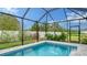Refreshing screened pool with a view of the backyard at 5252 Willow Lake Ct, Sarasota, FL 34233