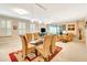 Open dining area with glass table, tan chairs, and access to living room at 5306 Manorwood Dr # 2A, Sarasota, FL 34235