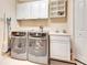 Well-equipped laundry room with washer, dryer, cabinets, and sink at 5306 Manorwood Dr # 2A, Sarasota, FL 34235