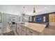 Open kitchen with white cabinets, large island, and pendant lighting at 5433 Hope Sound Cir, Sarasota, FL 34238