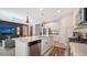 Modern kitchen featuring stainless steel appliances, white cabinets, and a large island with marble countertops at 5433 Hope Sound Cir, Sarasota, FL 34238