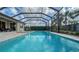 Backyard pool with screen enclosure, surrounded by lush landscaping and comfortable lounge chairs at 5433 Hope Sound Cir, Sarasota, FL 34238