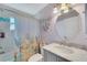 Bathroom with a marble countertop and floral shower curtain at 585 Purdy St, Englewood, FL 34223