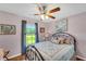 Bedroom with a metal bed frame, ceiling fan, and large window at 585 Purdy St, Englewood, FL 34223