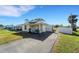 Cute bungalow with a fenced yard, driveway, and white gate at 585 Purdy St, Englewood, FL 34223