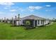 Beautiful backyard featuring a screened lanai, manicured landscaping, and lush green grass at 6005 Mesa Gln, Bradenton, FL 34203