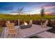 Outdoor fire pit area with Adirondack chairs and a stunning sunset view, perfect for gathering and enjoying the evening at 6005 Mesa Gln, Bradenton, FL 34203