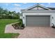 This home has a lovely exterior with a gray garage door and a brick paver driveway and walkway at 6005 Mesa Gln, Bradenton, FL 34203