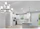 Bright kitchen features stainless steel appliances, white cabinetry, light hardwood floors and modern lighting at 6005 Mesa Gln, Bradenton, FL 34203