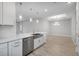 The kitchen has a stainless dishwasher, white cabinets, and a large undermount sink at 6005 Mesa Gln, Bradenton, FL 34203