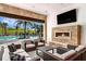 Elegant outdoor lounge with a fireplace, comfortable seating, and a view of the pool and landscaped grounds at 6005 Mesa Gln, Bradenton, FL 34203