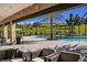 Beautiful community pool area with seating and views of lush green hills and palm trees on a sunny day at 6005 Mesa Gln, Bradenton, FL 34203