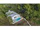 Single-story home with a metal roof and a pool; nestled in a tropical setting at 6061 Gulf Of Mexico Dr, Longboat Key, FL 34228