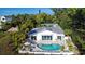 White house with a kidney-shaped pool, surrounded by lush tropical landscaping at 6061 Gulf Of Mexico Dr, Longboat Key, FL 34228