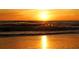 Golden sunset on the beach featuring ocean waves, sand, and a sunlit sky at 6061 Gulf Of Mexico Dr, Longboat Key, FL 34228