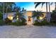 Bright white house with a courtyard entry and lush tropical landscaping at 6061 Gulf Of Mexico Dr, Longboat Key, FL 34228
