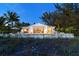 Beach house at dusk with pool and patio, beautifully lit at 6061 Gulf Of Mexico Dr, Longboat Key, FL 34228