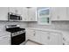 Modern kitchen featuring stainless steel appliances, white cabinets, and sleek countertops for a contemporary feel at 6107 Mesa Gln, Bradenton, FL 34203