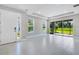 Bright living room with tile flooring, large windows, and a sliding glass door to a serene outdoor space at 6107 Mesa Gln, Bradenton, FL 34203