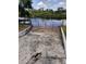 Concrete boat ramp and red gate for water access and lake views with lush greenery on the opposite bank at 6504 Lincoln Rd, Bradenton, FL 34203