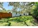 Spacious backyard featuring lush green grass, mature trees, and a privacy fence, perfect for outdoor activities at 730 40Th St, Sarasota, FL 34234