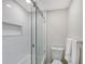 Clean, tiled bathroom featuring shower with glass doors, toilet, and recessed shelving at 730 40Th St, Sarasota, FL 34234