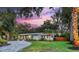 Charming home with a circular driveway, manicured lawn and exterior lighting at 730 40Th St, Sarasota, FL 34234
