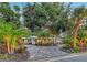 Beautifully landscaped home featuring circular paver driveway and lush tropical foliage at 730 40Th St, Sarasota, FL 34234