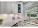 Well-lit kitchen featuring white cabinets, marble countertops, and a view of the outdoors at 730 40Th St, Sarasota, FL 34234