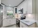 Stylish kitchen with white cabinets, stainless steel appliances, and beautiful herringbone backsplash at 730 40Th St, Sarasota, FL 34234